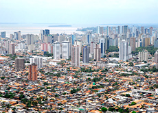 #ParaTodosVerem: imagem aérea da cidade de Belém. Em primeiro plano, casas populares; em segundo plano, edifícios residenciais e comerciais; e, ao fundo, a Baía do Guajará.